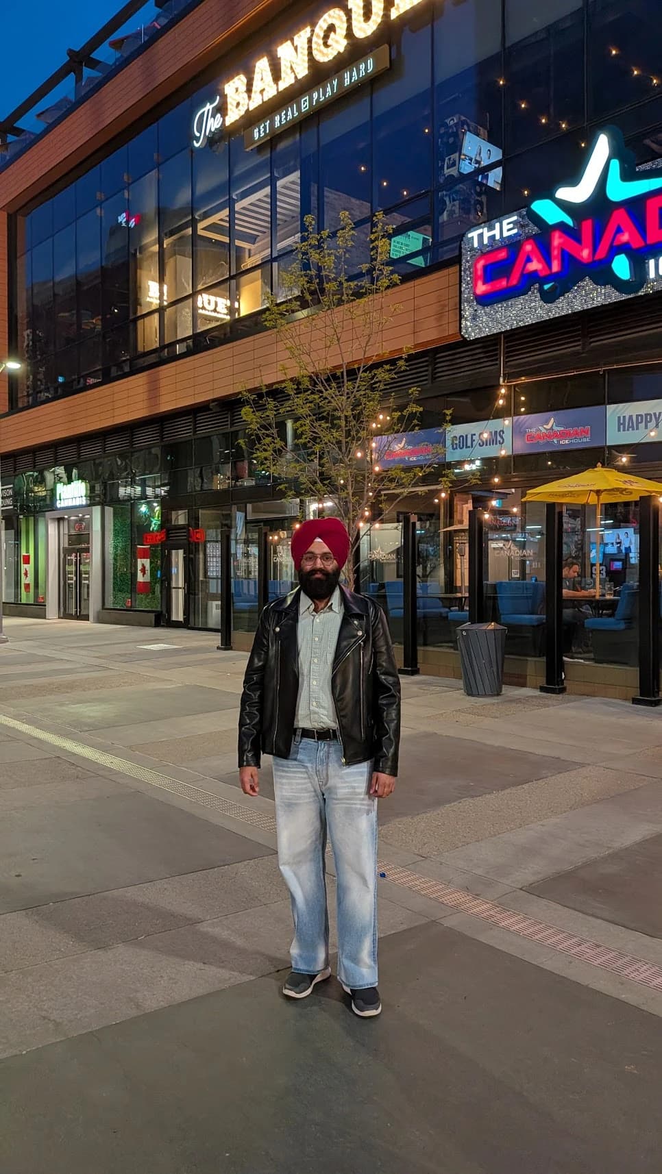 Karamveer Singh Sidhu standing outside restaurants on a city street at night